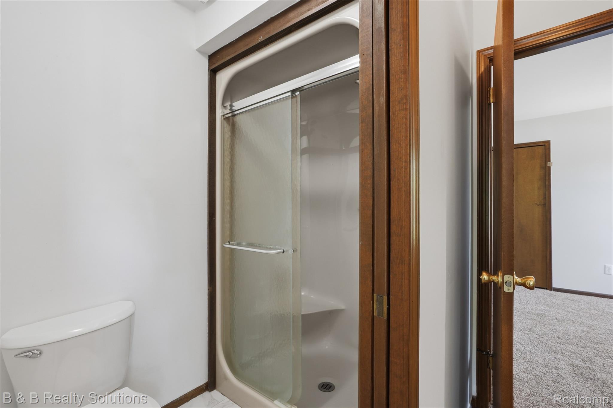 780 North Van Dyke Road, Unit APARTMENT #1 Almont, MI 48003 - Photo 20 of 28 Fiberglass shower enclosure with sliding glass doors, integrated shelving, and dark wood-finish trim