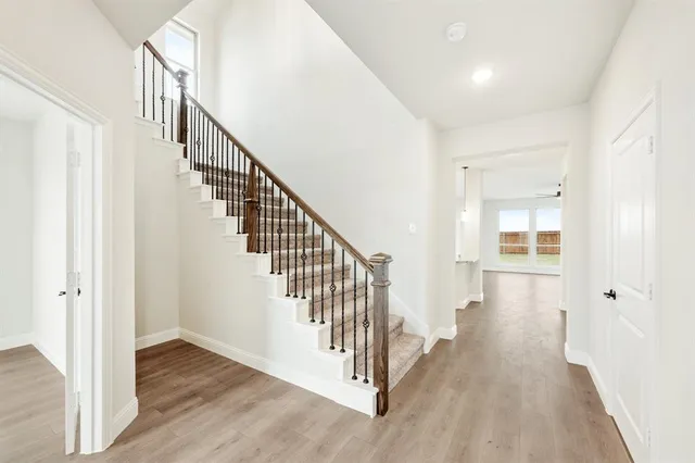 a view of a hallway with wooden floor and entryway