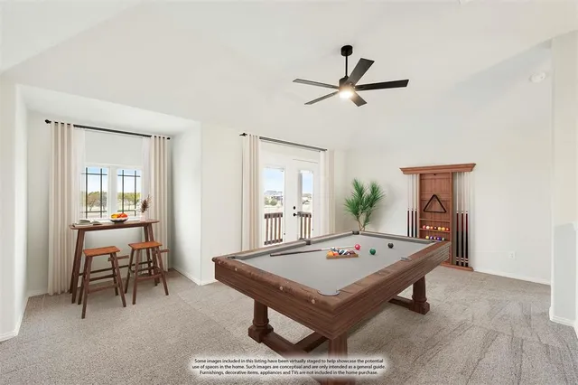 a living room with furniture pool table and paintings on the wall