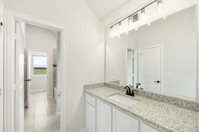 a bathroom with a granite countertop sink and a mirror