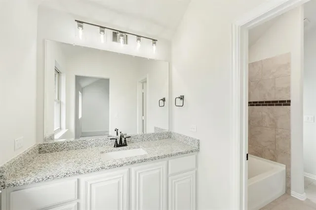 a bathroom with a granite countertop sink and a mirror