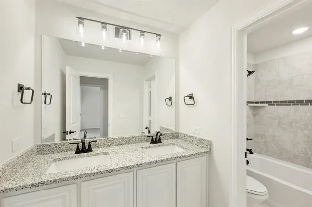 a bathroom with a granite countertop sink a mirror and a bathtub