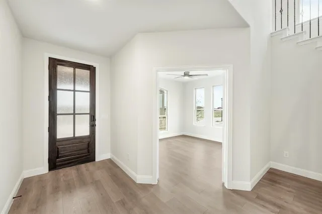 an empty room with wooden floor and mirror