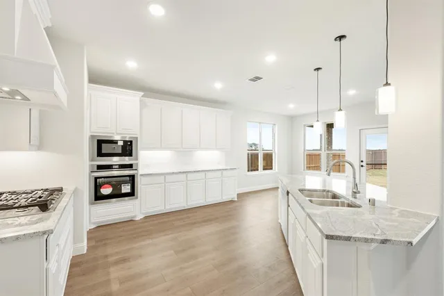 a kitchen with stainless steel appliances kitchen island a sink a stove and a refrigerator