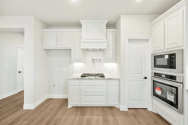 a kitchen with white cabinets and appliances