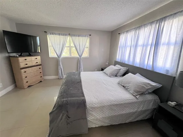 a bedroom with a bed and flat screen tv