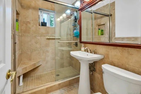 a bathroom with a sink a toilet and shower
