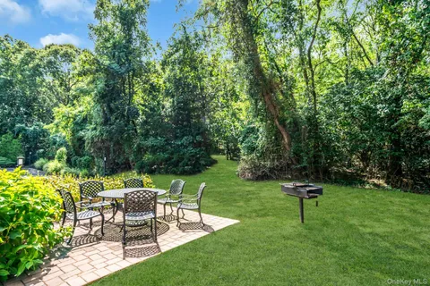 a view of a backyard with chairs and a garden