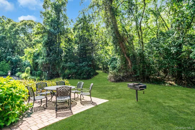 a view of a backyard with chairs and a garden