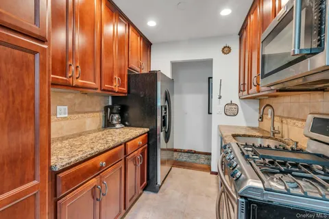 a kitchen with stainless steel appliances granite countertop a stove a refrigerator and a sink
