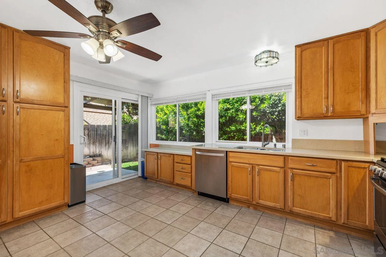14215 Sutter Mill Way Poway, CA 92064 - Photo 30 of 38 a large white kitchen with a window and refrigerator