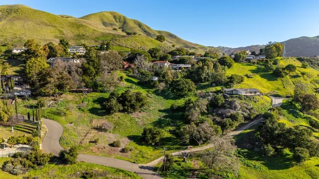 a view of a houses with a lush green hillside