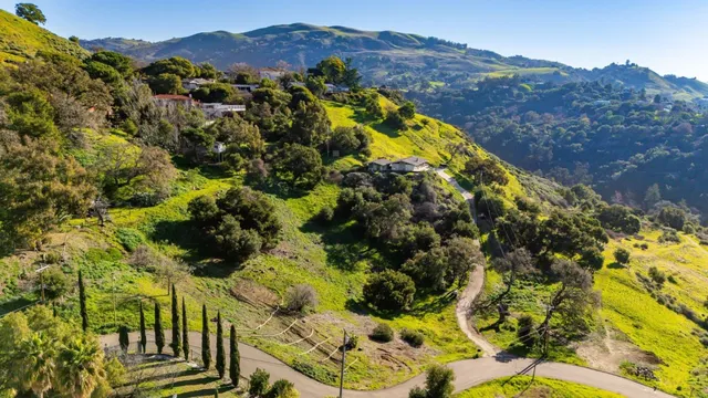 a view of a houses with a lush green hillside