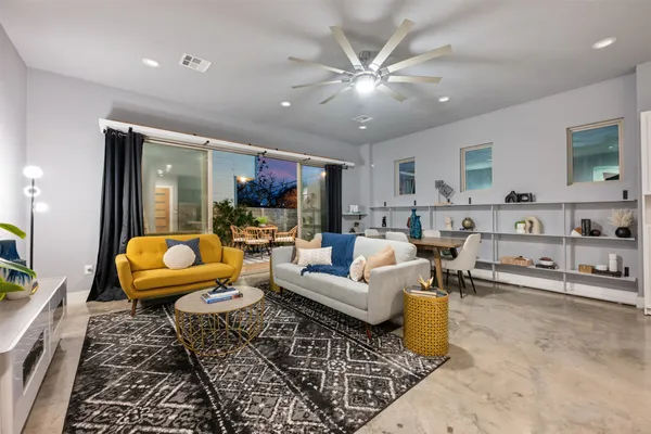 a living room with furniture and a view of kitchen