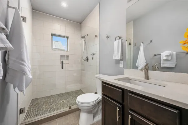 a bathroom with a sink a toilet and shower