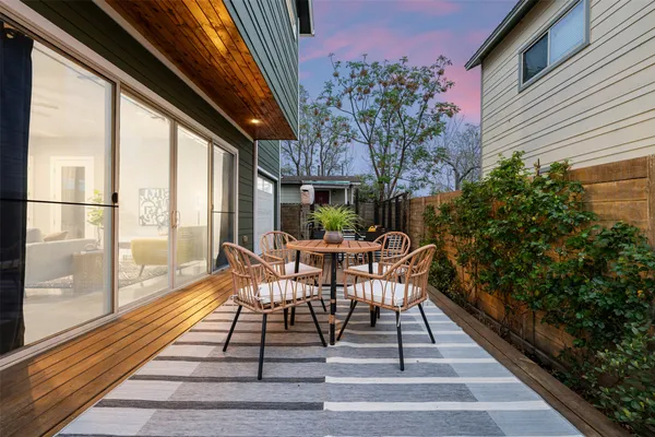 a view of a patio with table and chairs and wooden floor