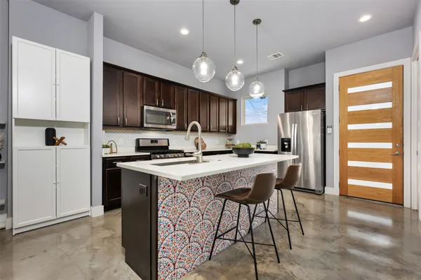 a kitchen with kitchen island granite countertop wooden cabinets and a refrigerator