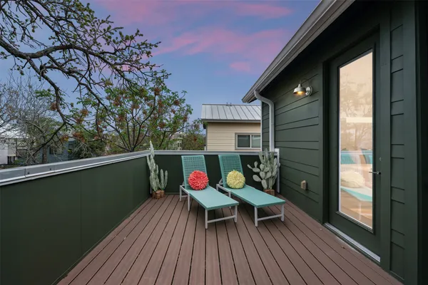 a balcony with wooden floor table and chairs