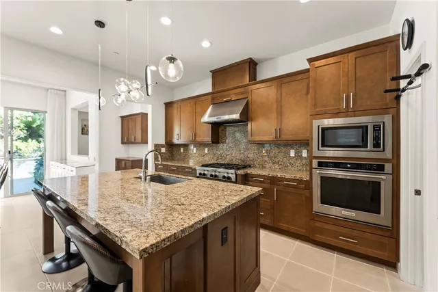 a kitchen with stainless steel appliances granite countertop a stove microwave and cabinets