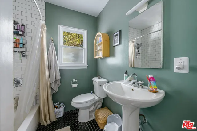 a bathroom with a sink toilet and a mirror