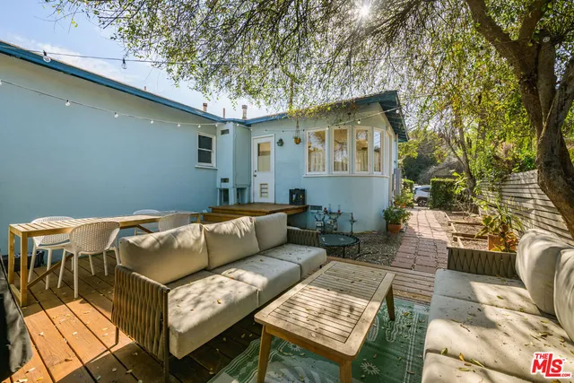 a view of a patio with couches and a table and chairs with wooden floor