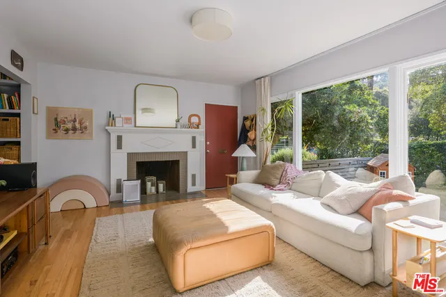 a living room with furniture fireplace and a large window