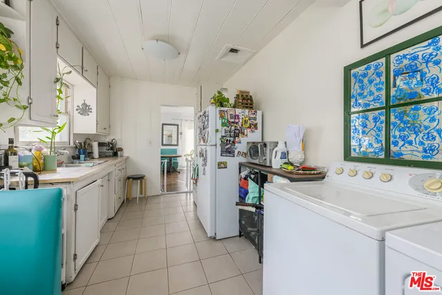 a view of a kitchen with fridge and workspace