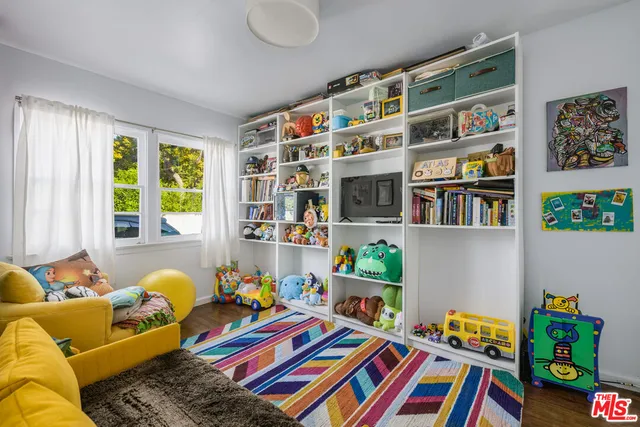 a living room filled with lots of furniture and a book shelf