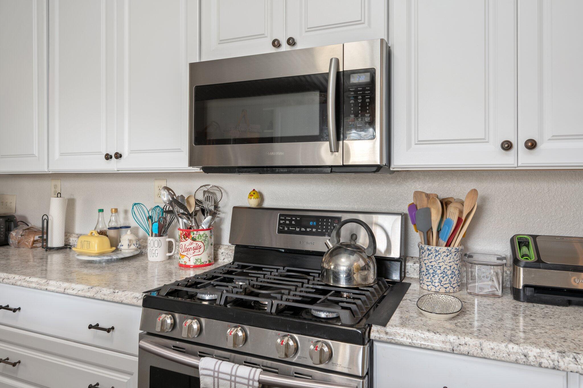 2288 Caton Road Florala, AL 36442 - Photo 6 of 47 a kitchen with granite countertop a stove and white cabinets