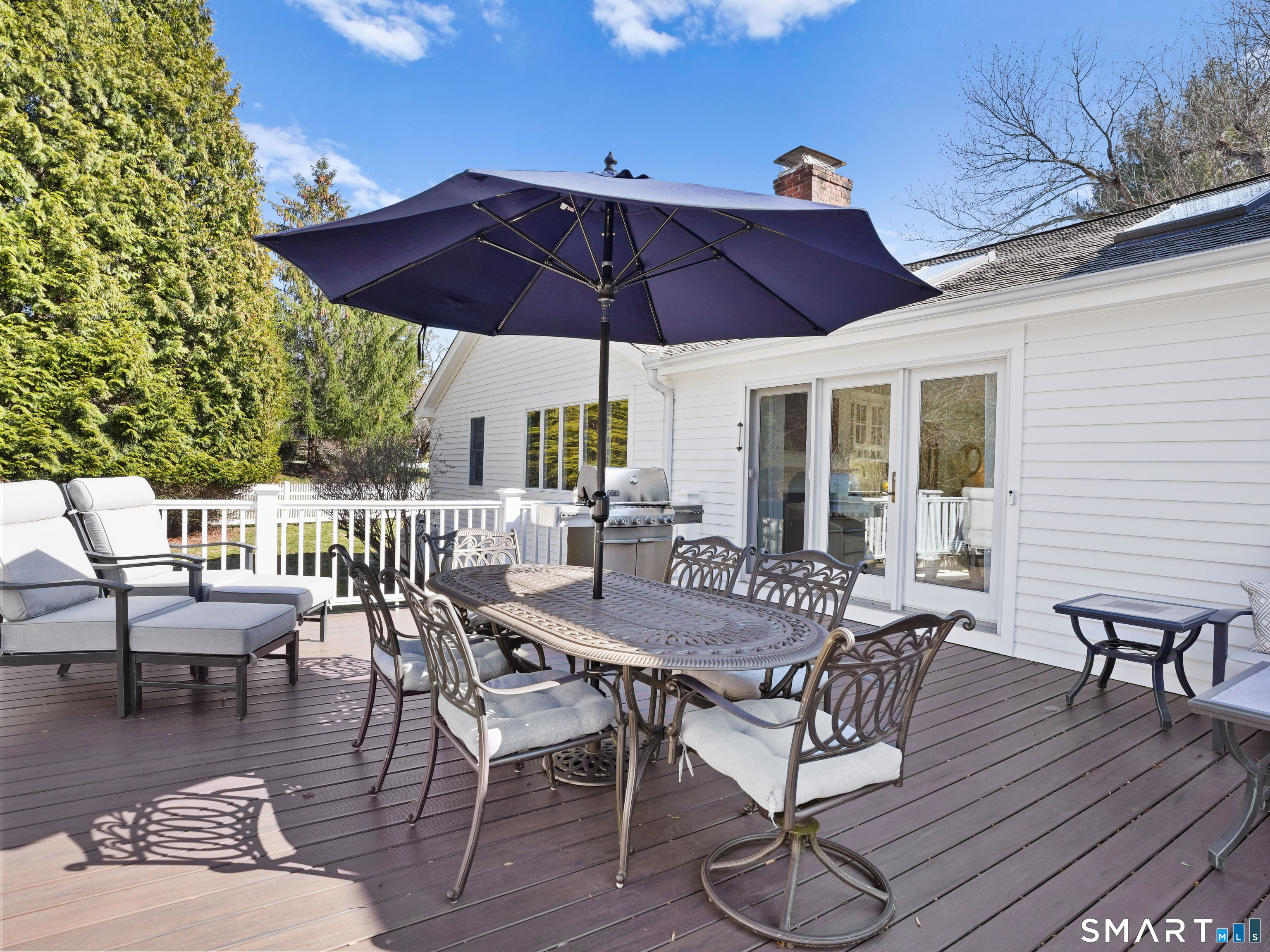 10 Reimer Road Westport, CT 06880 - Photo 29 of 38 a view of a patio with table and chairs under an umbrella with wooden floor