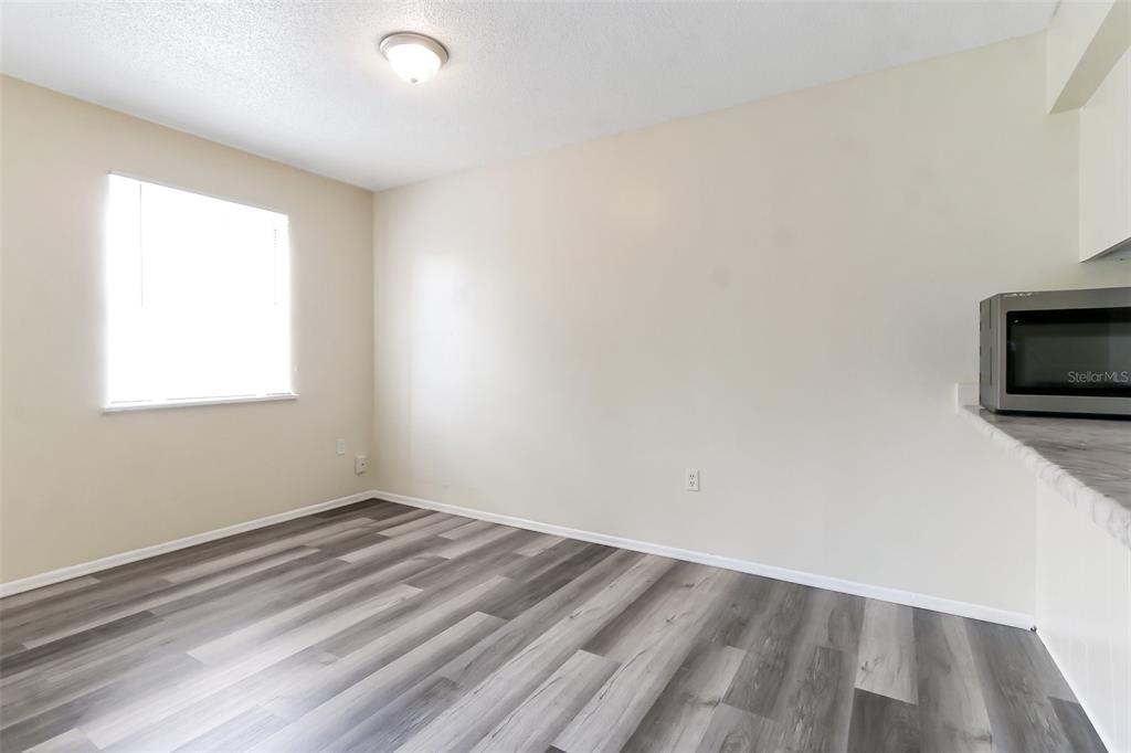 5317 Curry Ford Road, Unit J102 Orlando, FL 32812 - Photo 16 of 24 wooden floor in an empty room with a window