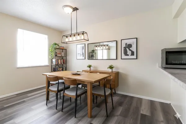 a view of kitchen and empty room with wooden floor