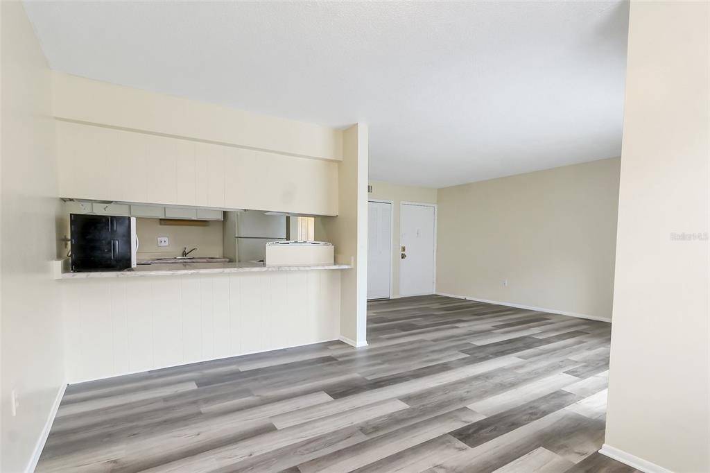 5317 Curry Ford Road, Unit J102 Orlando, FL 32812 - Photo 18 of 24 a view of kitchen and empty room with wooden floor