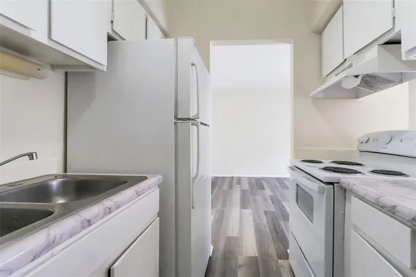 a kitchen with stainless steel appliances a white stove top oven and a refrigerator