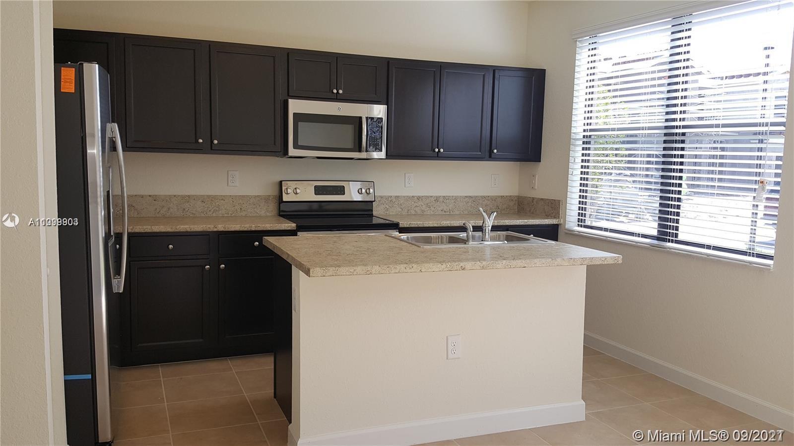 3778 Northeast 2nd Street Homestead, FL 33033 - Photo 1 of 15 a kitchen with a refrigerator stove and microwave
