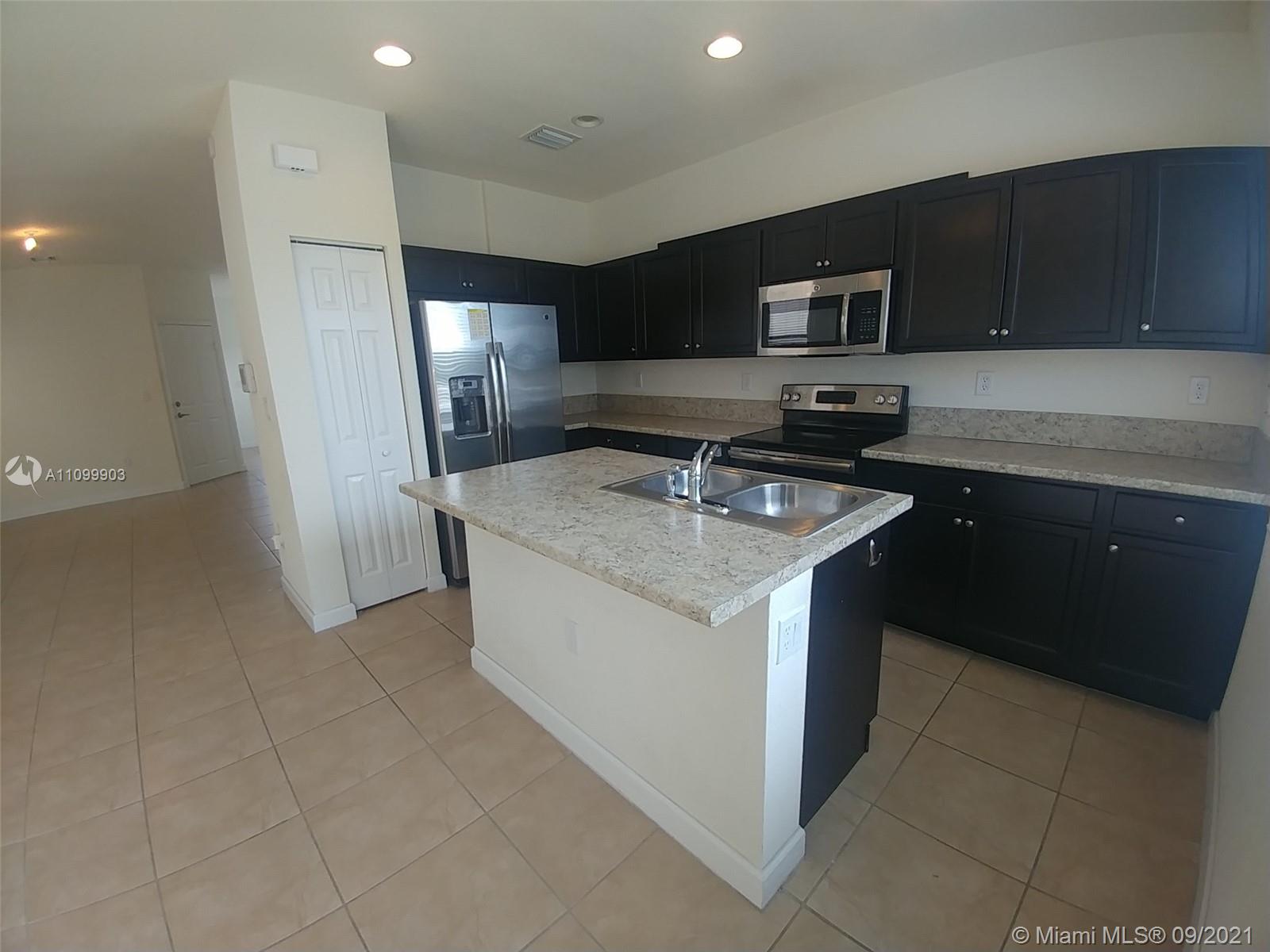 3778 Northeast 2nd Street Homestead, FL 33033 - Photo 7 of 15 a kitchen that has a sink and a stove top oven
