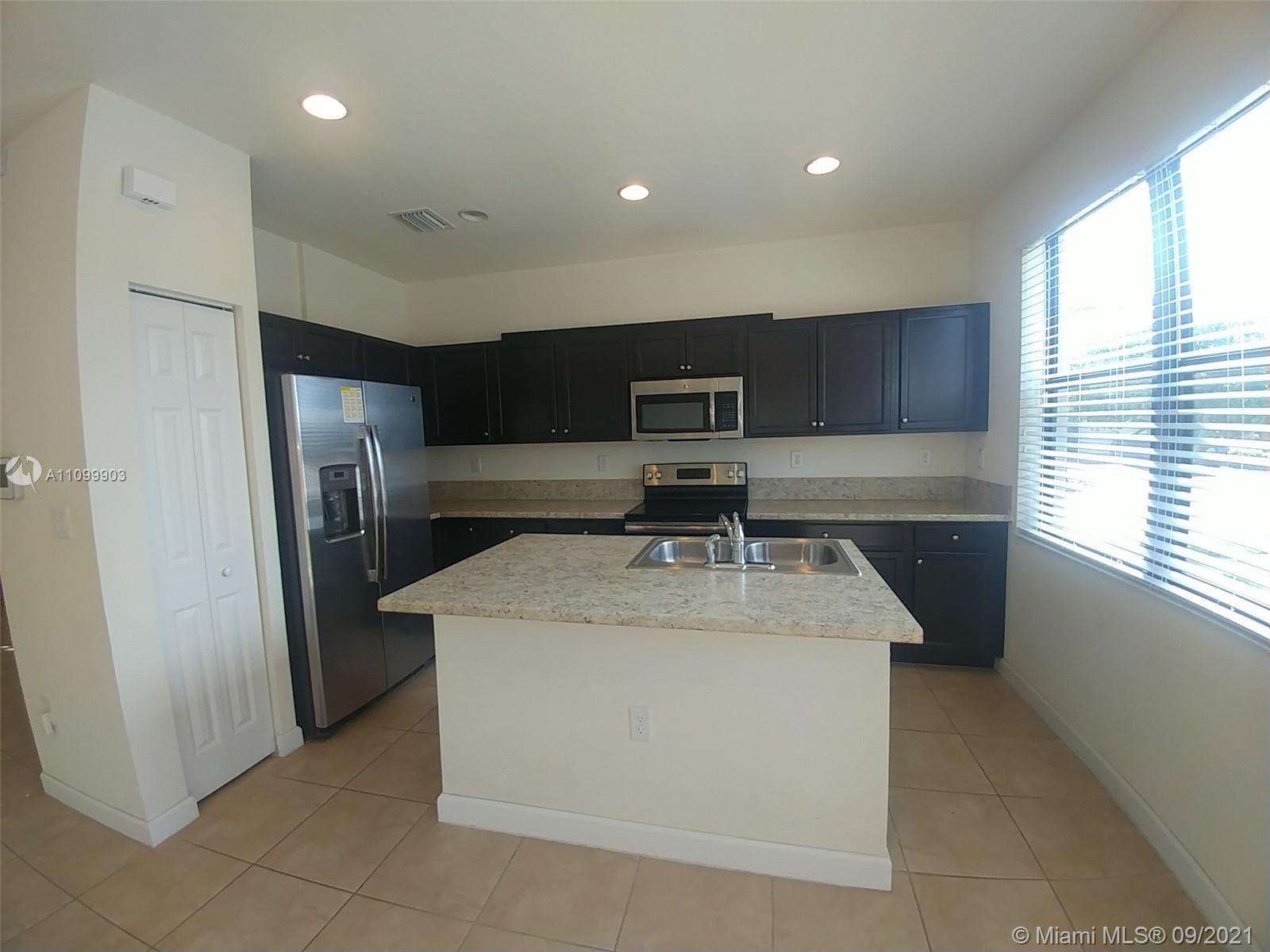 3778 Northeast 2nd Street Homestead, FL 33033 - Photo 9 of 15 a kitchen with stainless steel appliances granite countertop a sink a refrigerator and a stove
