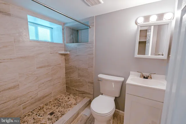 a white toilet sitting next to a bathroom sink