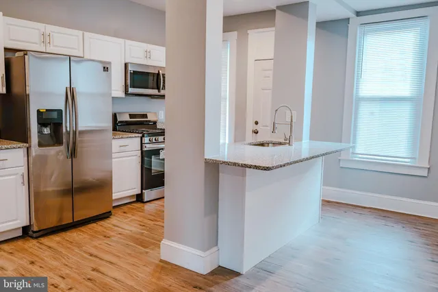 a kitchen with stainless steel appliances a refrigerator and a stove top oven