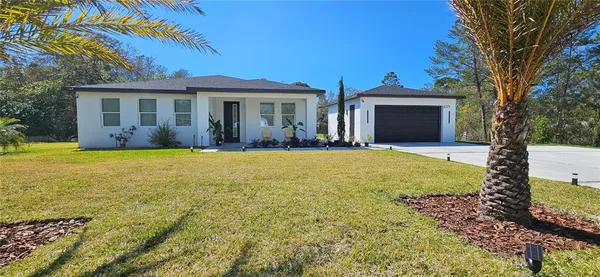 a view of a house with a yard and potted plants