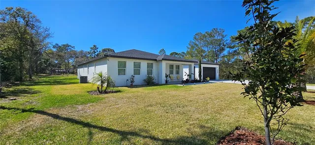 a view of a house with backyard and sitting area