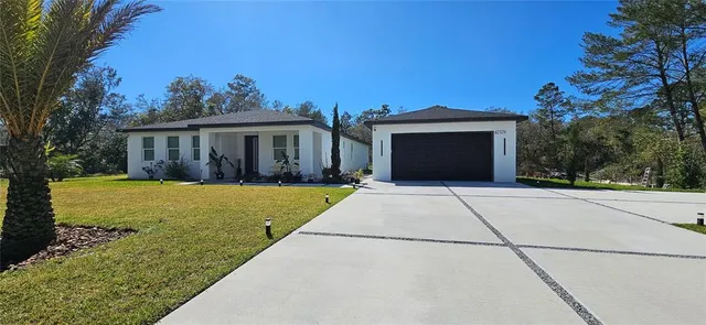 a front view of a house with a yard and trees