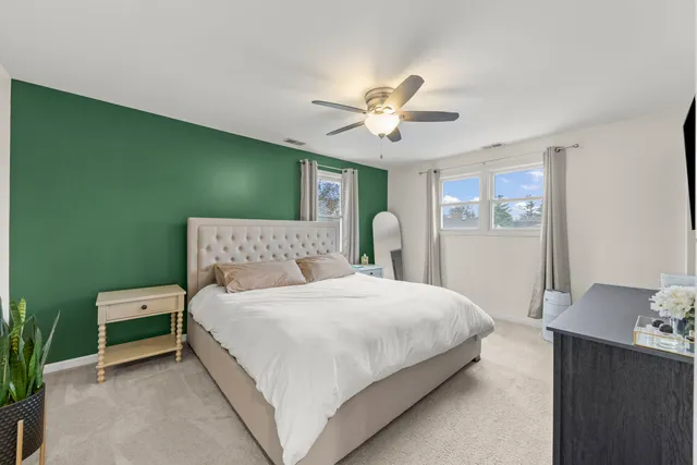 a bedroom with a bed chandelier and a window
