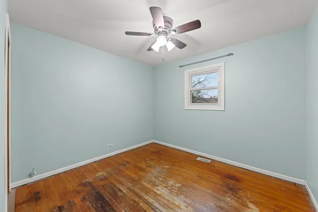 an empty room with a window and a fan