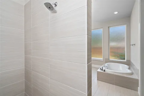 a spacious bathroom with a double vanity sink mirror and a bathtub