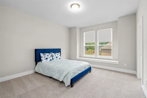a bedroom with a bed and large windows