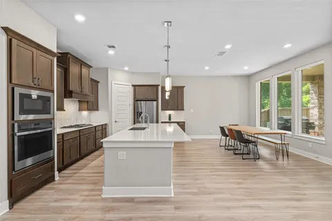 a large kitchen with stainless steel appliances kitchen island granite countertop a sink and cabinets