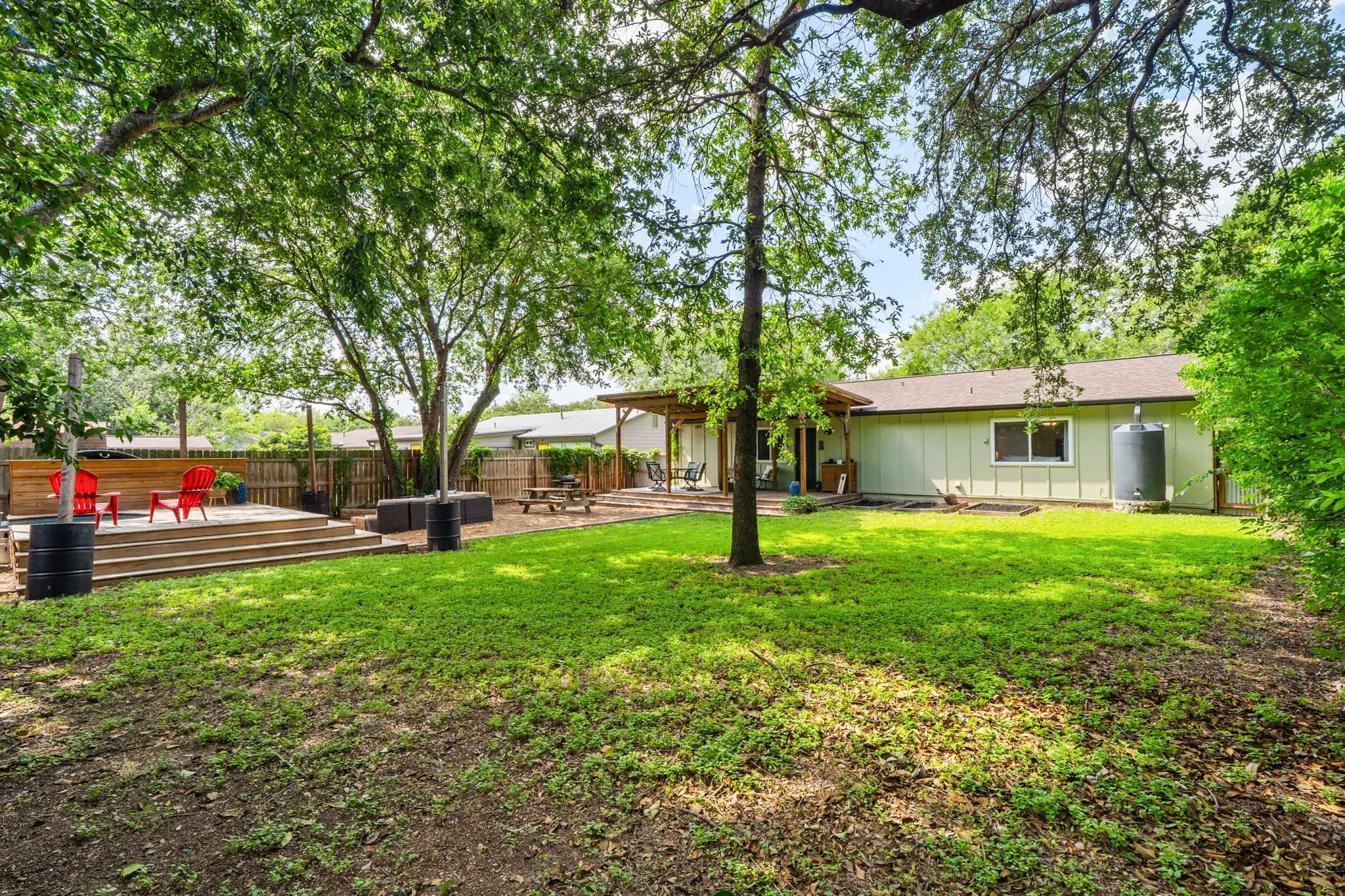 705 Dulwich Street Austin, TX 78748 - Photo 30 of 36 A spacious yard with mature shade trees leads to a multi-level deck, perfect for outdoor living and entertaining.