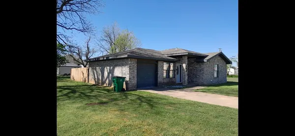 a view of a house with a big yard and large trees
