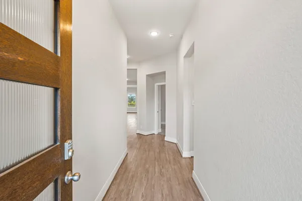 a view of a hallway with wooden floor